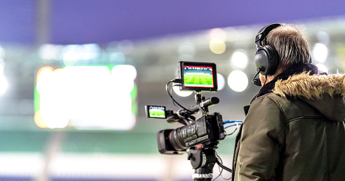 videographer watching sports game through camera